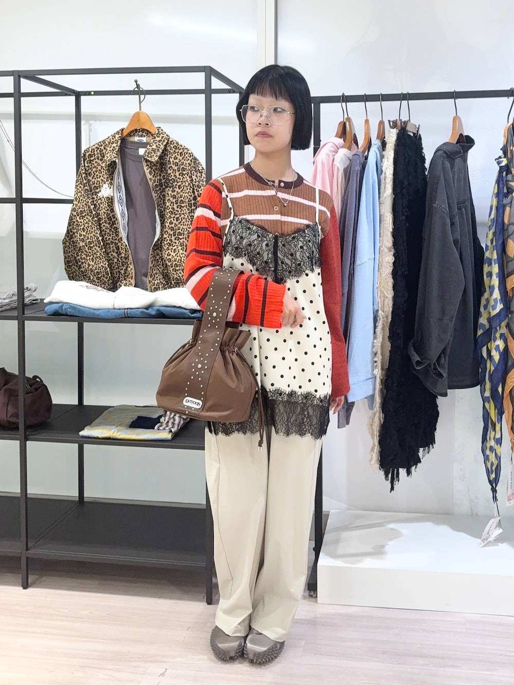 ブラウン系のニット/セーター、ブラウン系のショルダーバッグ、ベージュ系のその他パンツを着用したレディースの秋コーディネートの1枚目の写真