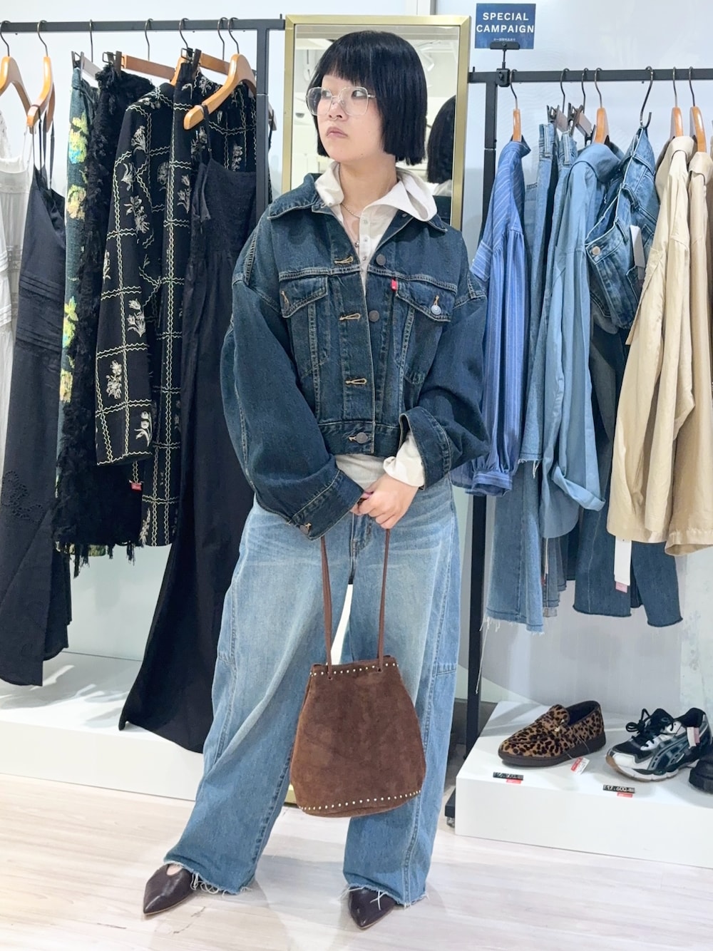 ベージュ系のTシャツ/カットソー、ブルー系のデニムパンツ、ブラウン系のショルダーバッグを着用したレディースの秋コーディネートの1枚目の写真