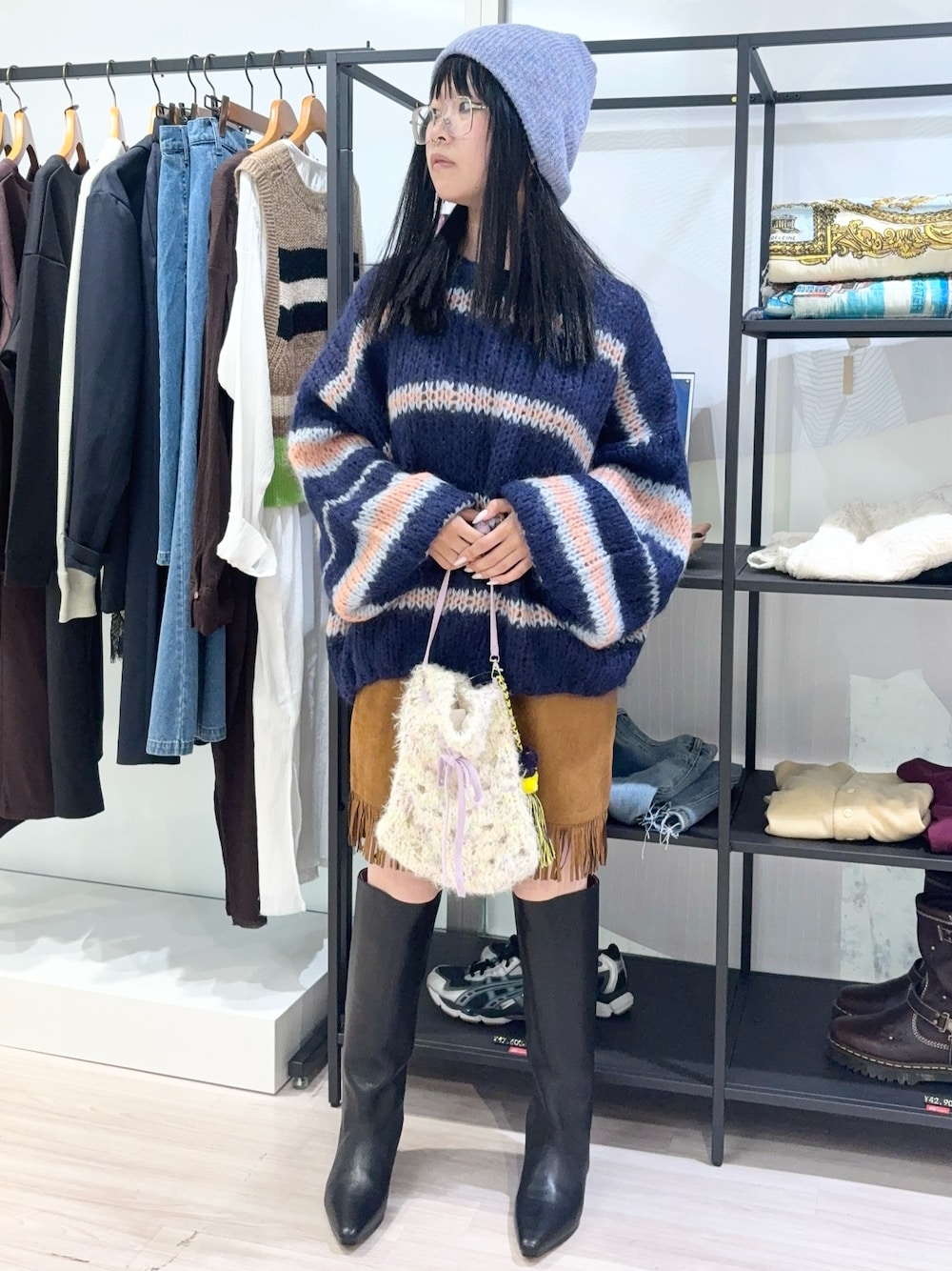 ブルー系のニット/セーター、ホワイト系のショルダーバッグ、ブラウン系のスカートを着用したレディースの秋コーディネートの1枚目の写真