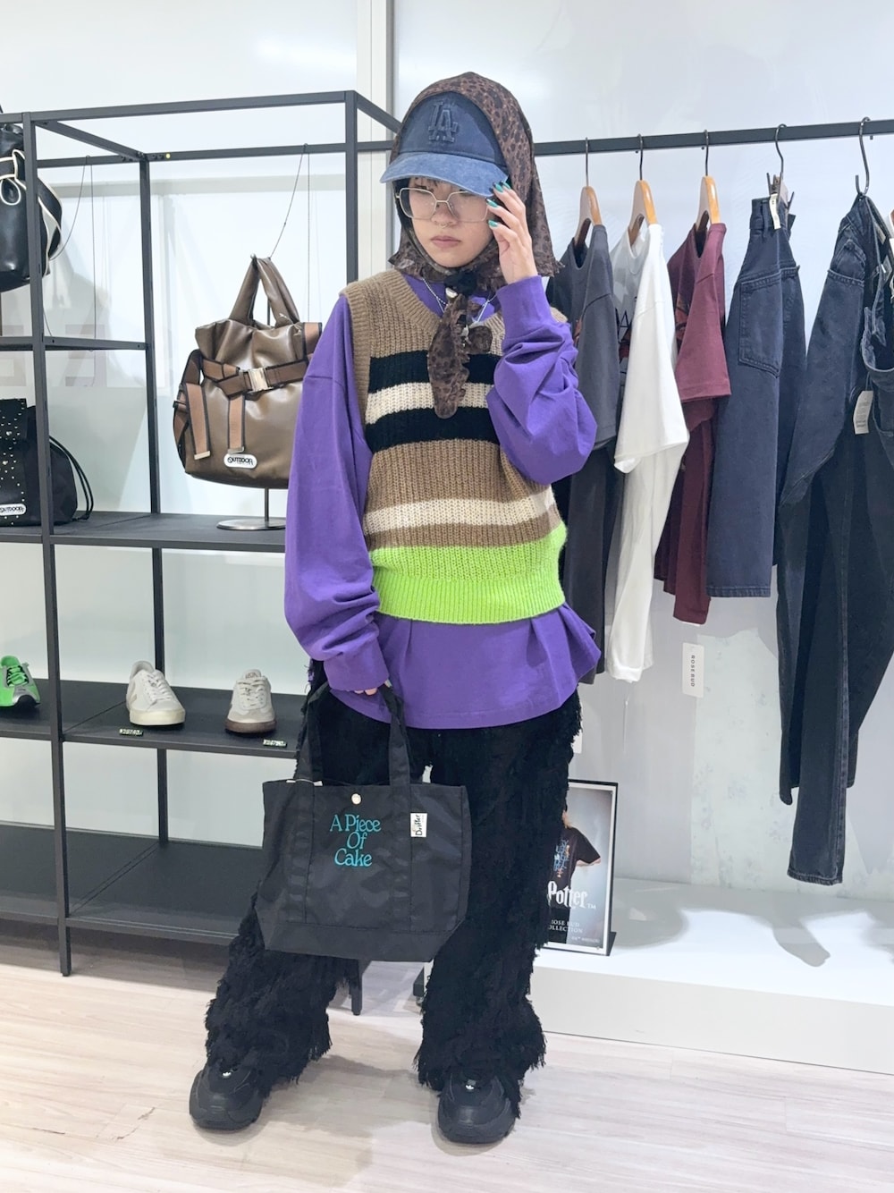 ブラック系のトートバッグ、パープル系のTシャツ/カットソー、ベージュ系のベストを着用したレディースの秋コーディネートの1枚目の写真