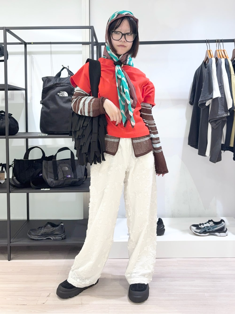 レッド系のTシャツ/カットソー、ブルー系のカーディガン/ボレロ、ホワイト系のその他パンツを着用したレディースの春コーディネートの1枚目の写真