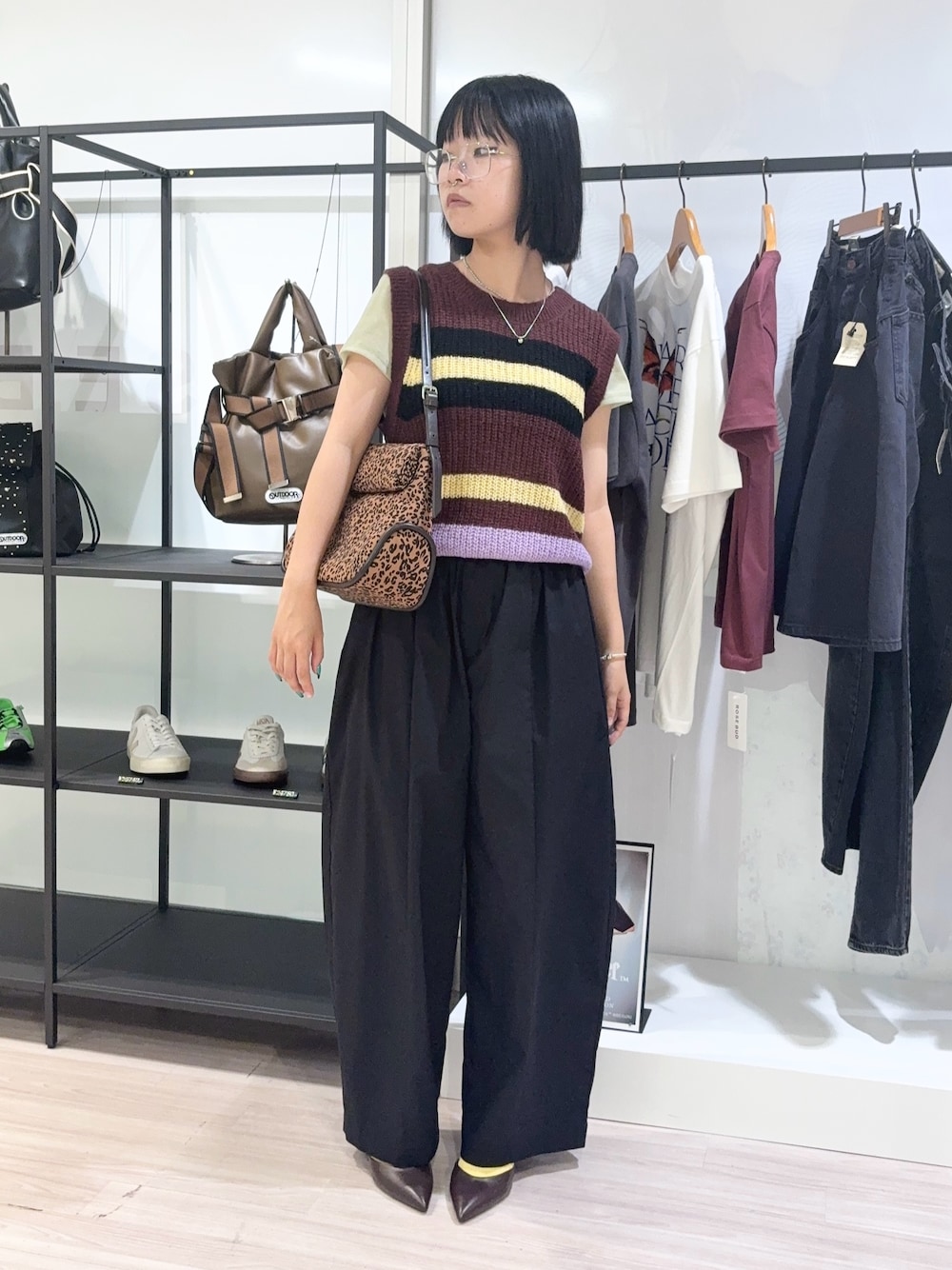 グリーン系のTシャツ/カットソー、ブラウン系のベスト、ブラック系のその他パンツを着用したレディースの秋コーディネートの1枚目の写真