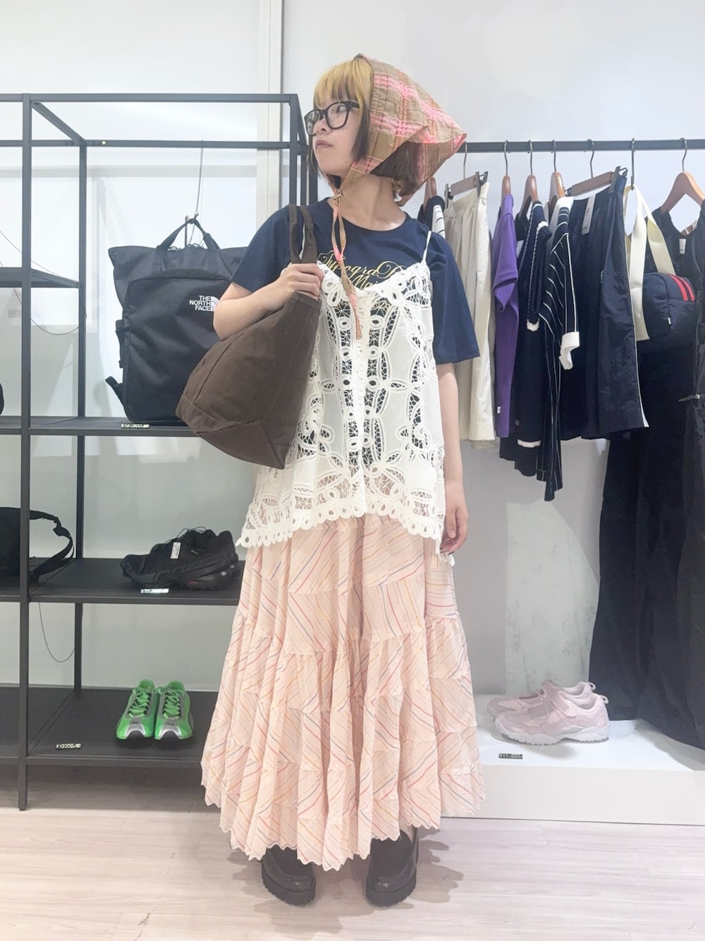 ブラウン系のトートバッグ、ホワイト系のキャミソール、ブルー系のTシャツ/カットソーを着用したレディースの春コーディネートの1枚目の写真