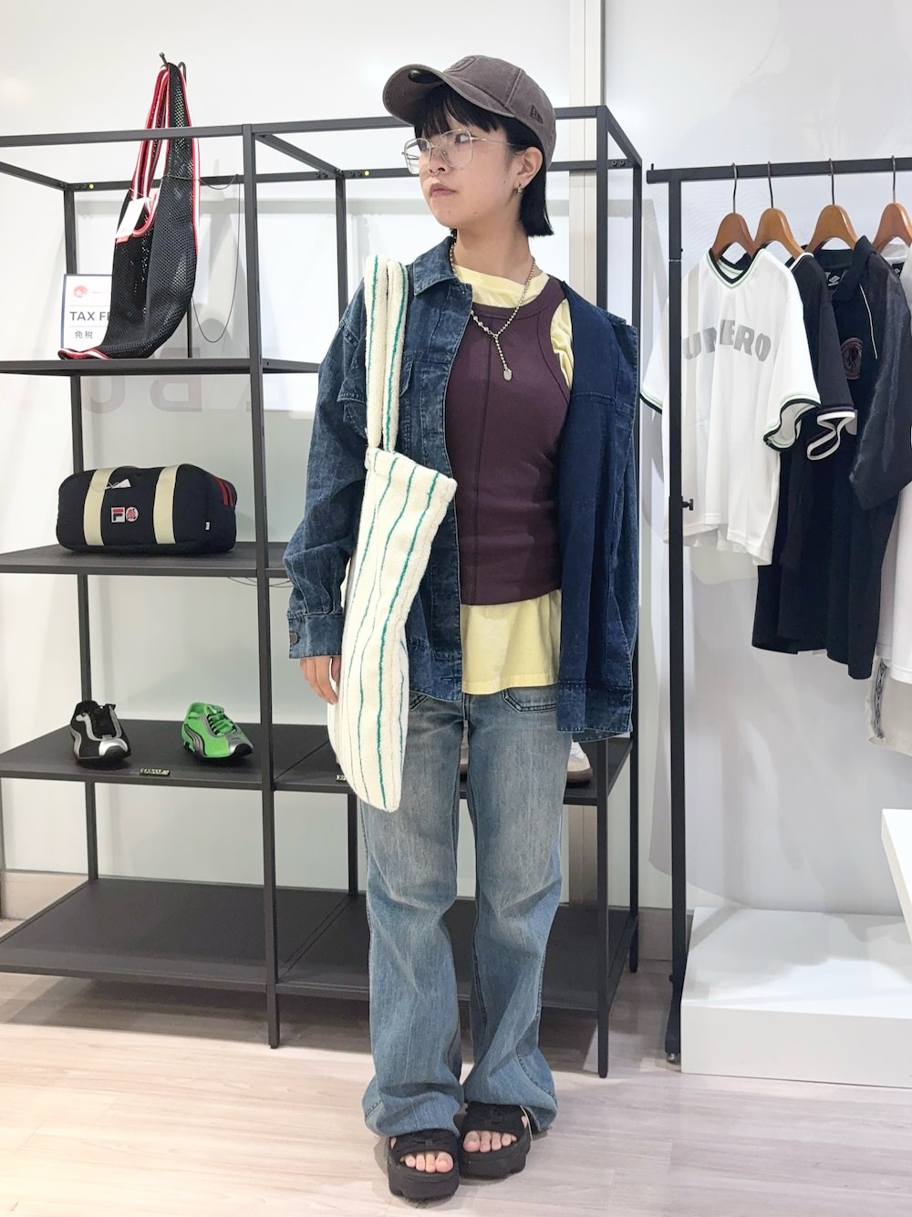 ブルー系のデニムパンツ、ブラック系のサンダル、イエロー系のTシャツ/カットソーを着用したレディースの夏コーディネートの1枚目の写真