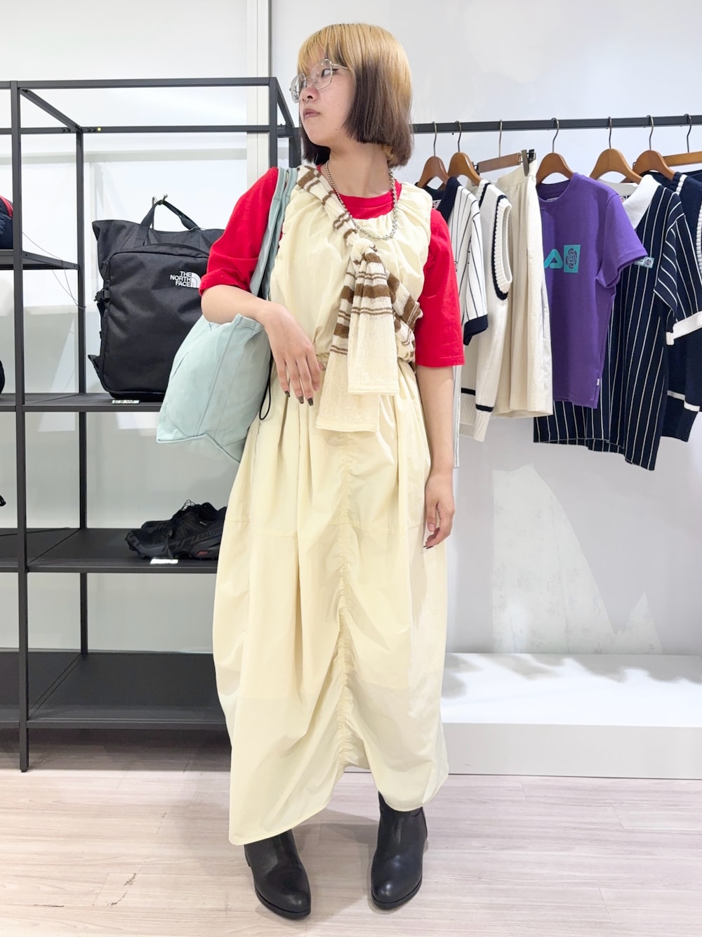 ブラック系のブーツ、ホワイト系のカーディガン/ボレロ、レッド系のTシャツ/カットソーを着用したレディースの夏コーディネートの1枚目の写真
