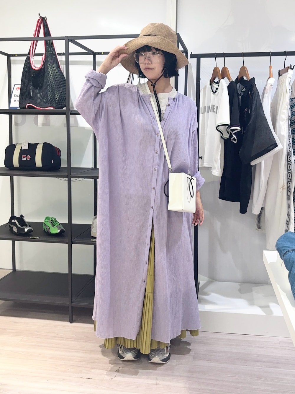 ホワイト系のショルダーバッグ、ベージュ系のTシャツ/カットソー、イエロー系のスカートを着用したレディースの夏コーディネートの1枚目の写真