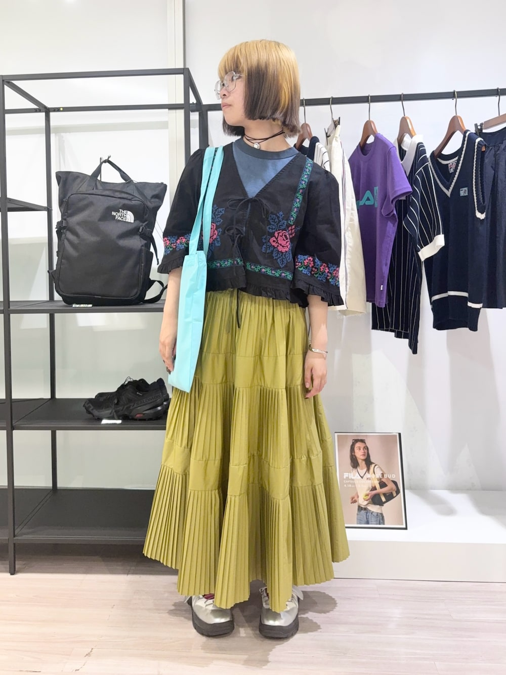ブラック系のスカート、ブラック系のシャツ/ブラウス、ブルー系のトートバッグを着用したレディースの夏コーディネートの1枚目の写真
