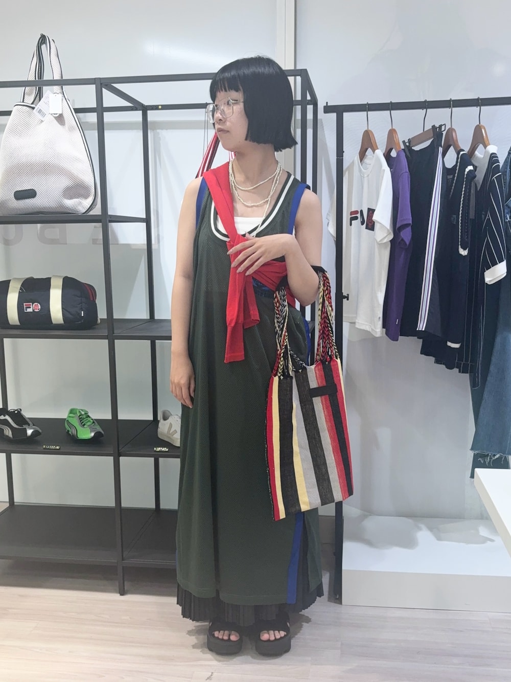 レッド系のニット/セーター、レッド系のショルダーバッグ、ブラック系のサンダルを着用したレディースの夏コーディネートの1枚目の写真