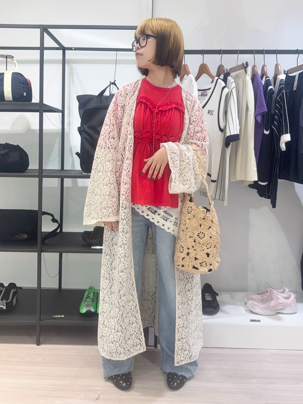 ホワイト系のワンピース、ブルー系のデニムパンツ、ベージュ系のショルダーバッグを着用したレディースの春コーディネートの1枚目の写真