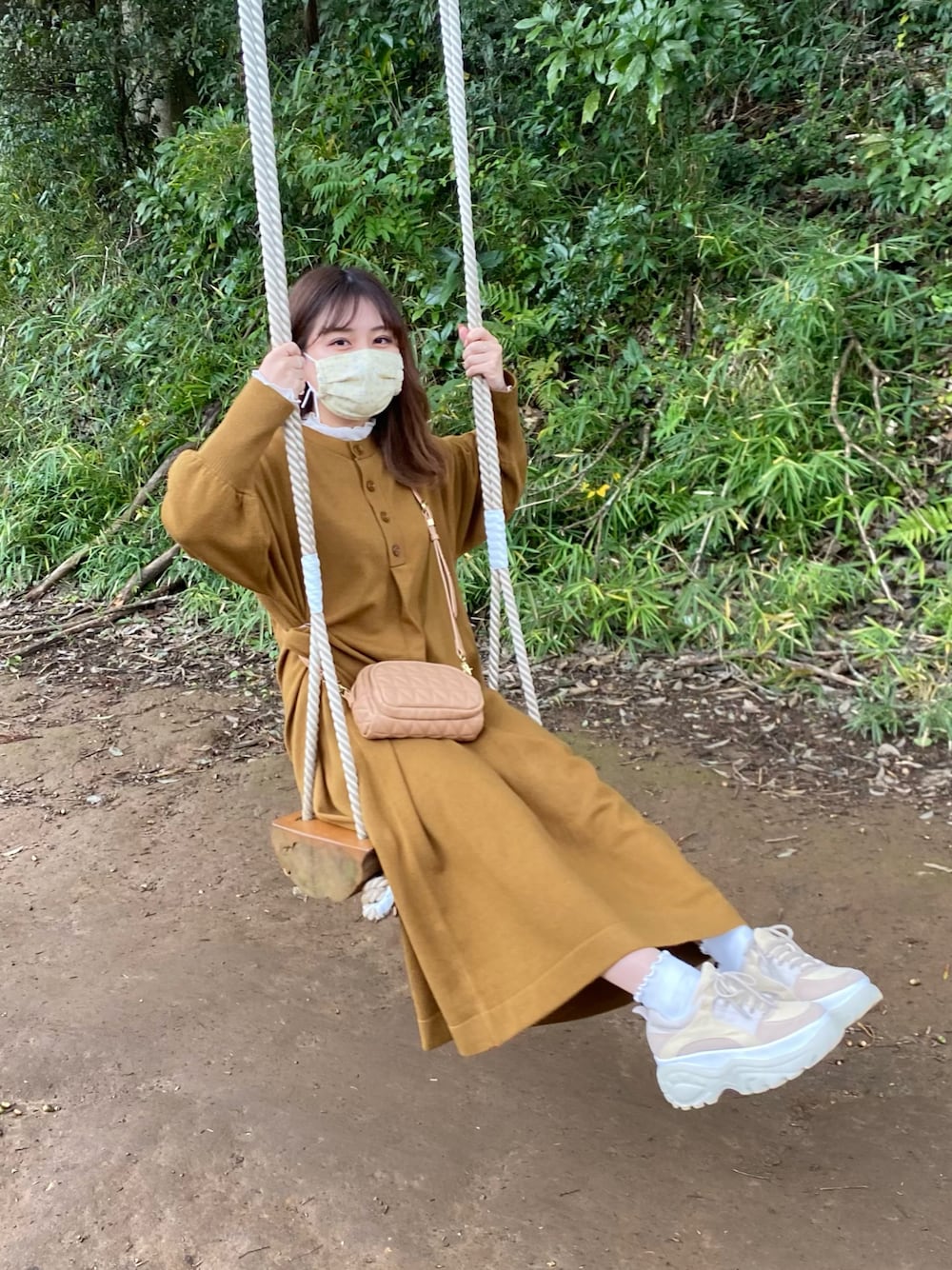 ブラウン系のワンピース、ベージュ系のスニーカー、ホワイト系のTシャツ/カットソーを着用したレディースの秋コーディネートの1枚目の写真