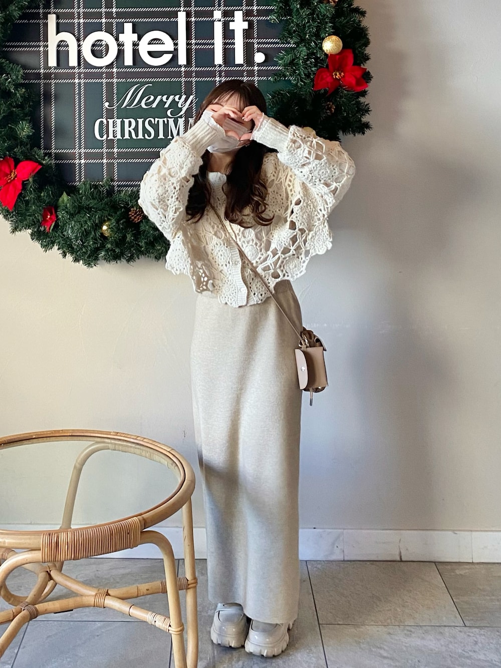 ホワイト系のニット/セーター、ホワイト系のTシャツ/カットソー、ベージュ系のショルダーバッグを着用したレディースの冬コーディネートの1枚目の写真