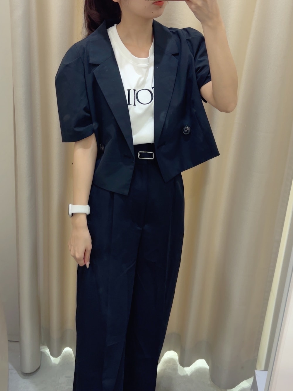 ブラック系のスラックス、ホワイト系のTシャツ/カットソー、ブラック系のテーラードジャケットを着用したレディースの夏コーディネートの2枚目の写真