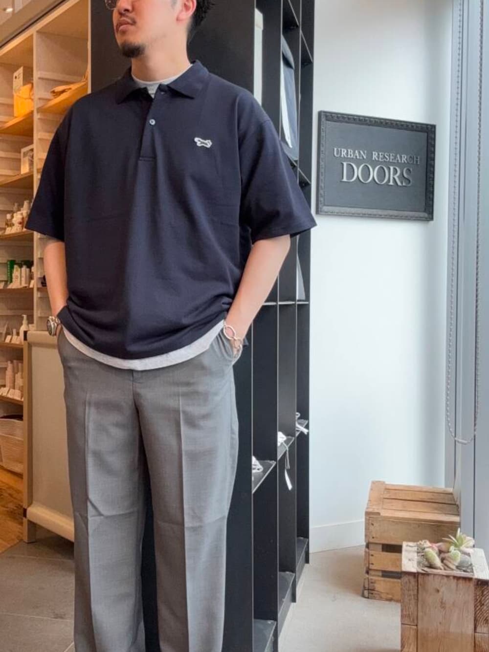 ブルー系のポロシャツ、グレー系のスラックスを着用したメンズの夏コーディネートの1枚目の写真
