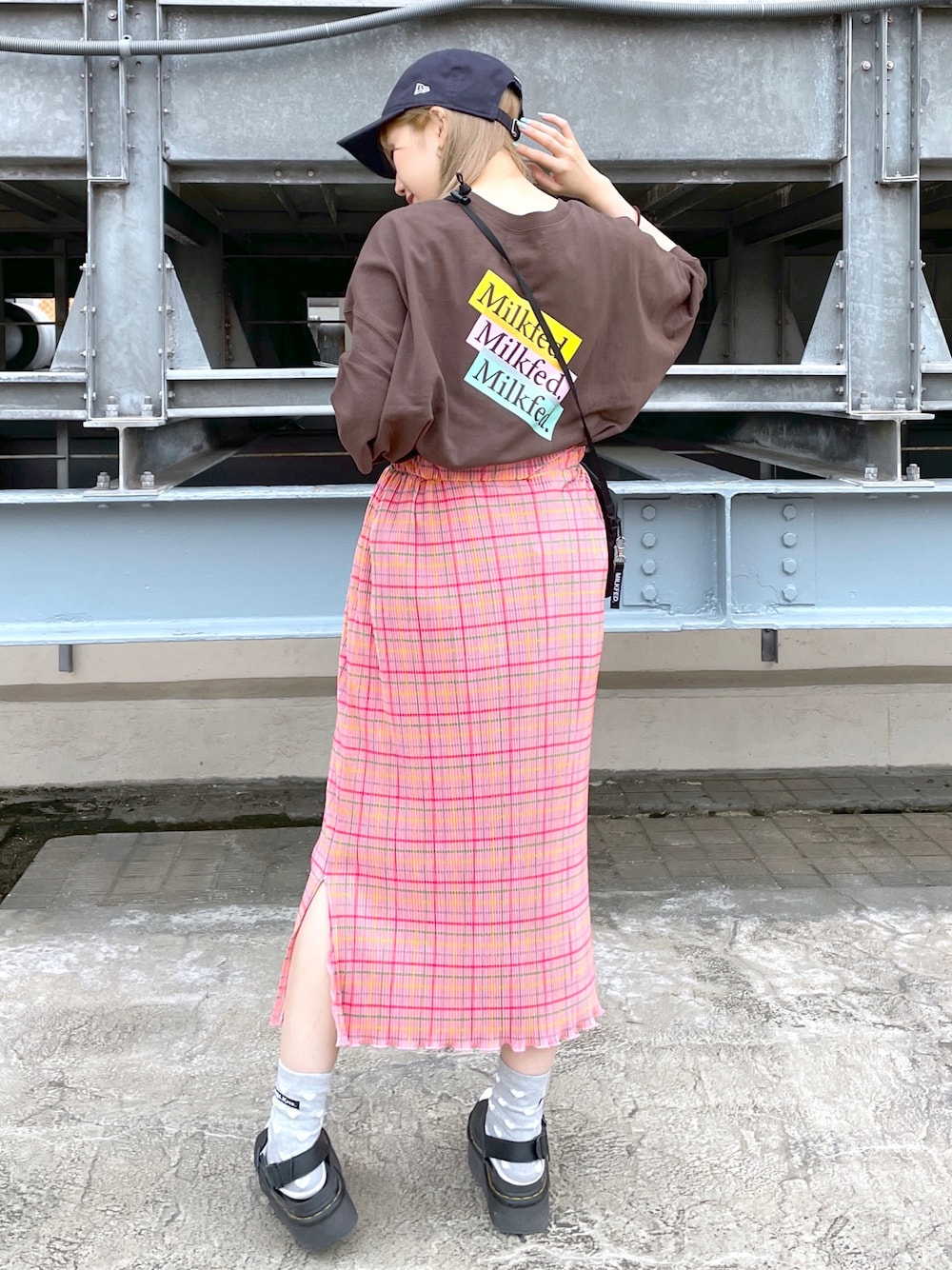 ブラウン系のTシャツ/カットソー、ピンク系のスカート、ブラック系のショルダーバッグを着用したレディースの夏コーディネートの1枚目の写真