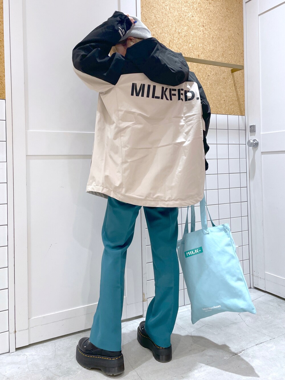 ホワイト系のマウンテンパーカー、グリーン系のその他パンツ、ブルー系のトートバッグを着用したレディースの秋コーディネートの1枚目の写真