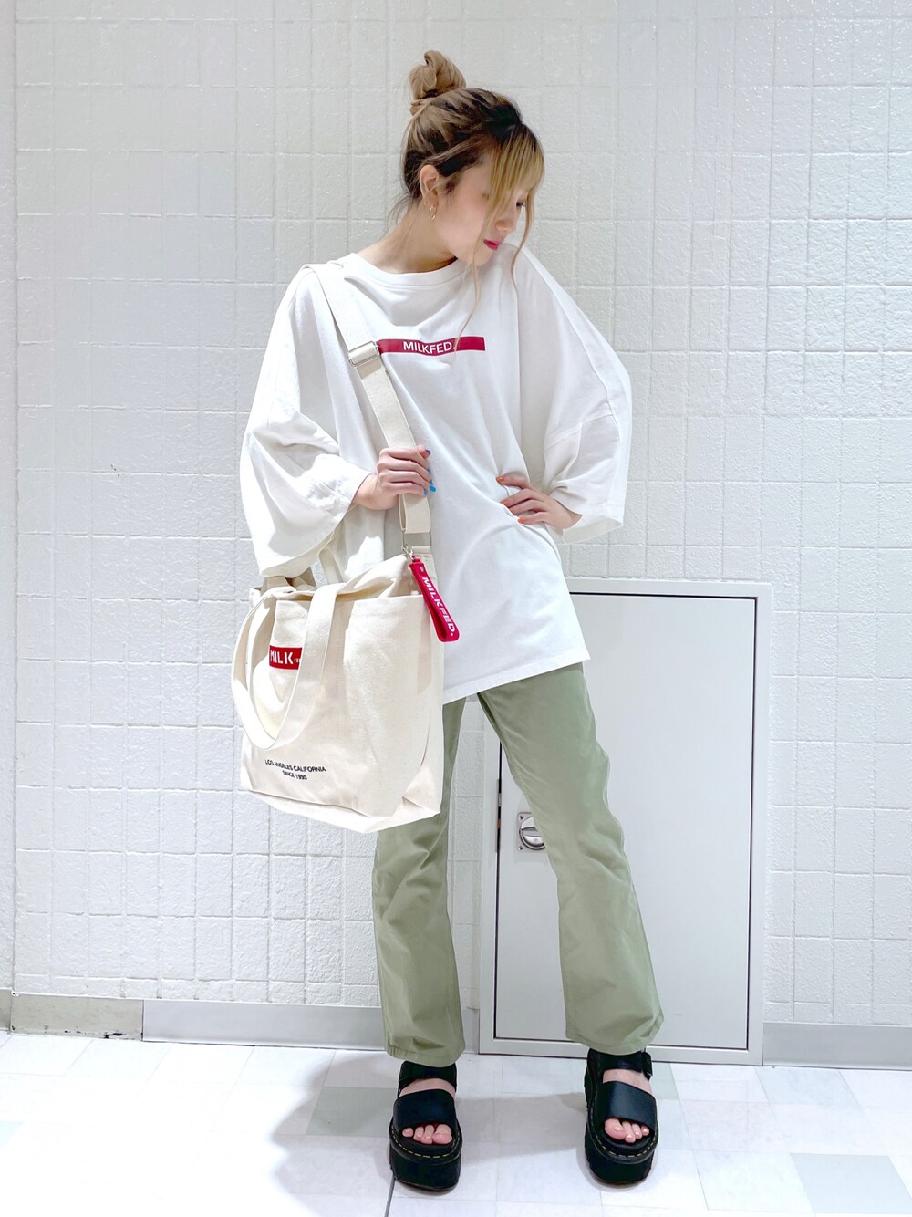 ホワイト系のTシャツ/カットソー、その他のトートバッグ、グリーン系のチノパンツを着用したレディースの夏コーディネートの1枚目の写真