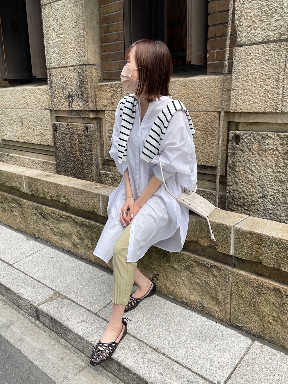 ホワイト系のシャツ/ブラウス、ブラック系のニット/セーター、グリーン系のその他パンツを着用したレディースの春コーディネートの2枚目の写真