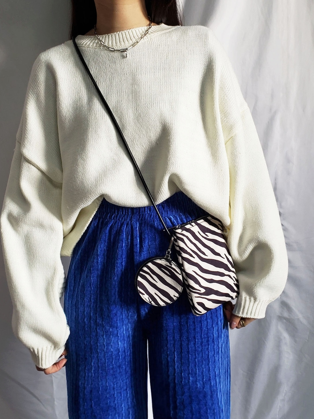 ブルー系のスラックス、ブラック系のニット/セーターを着用したレディースの冬コーディネートの4枚目の写真