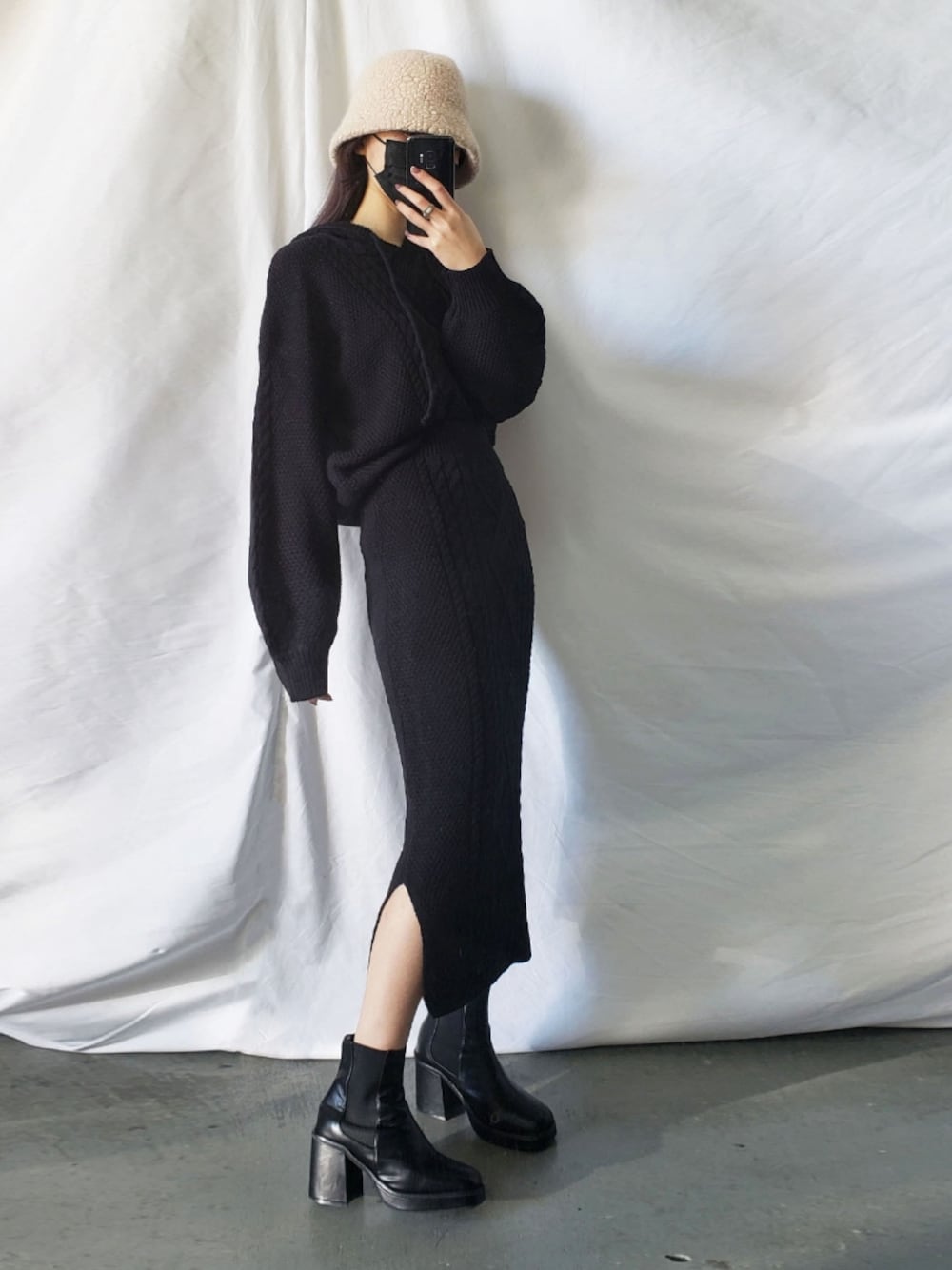 ブラック系のセットアップ、ベージュ系のハットを着用したレディースの冬コーディネートの1枚目の写真