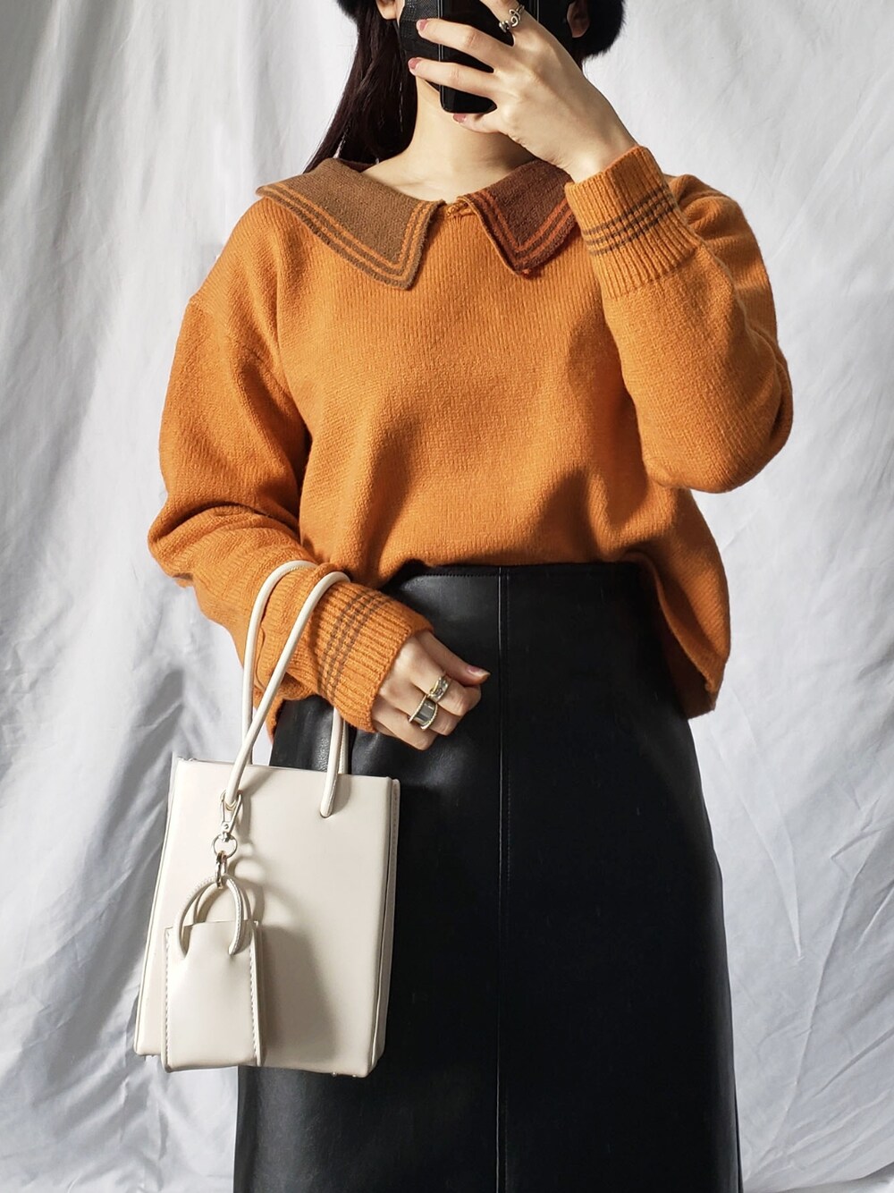 ホワイト系のスカート、ブラウン系のトートバッグ、ベージュ系のニット/セーターを着用したレディースの冬コーディネートの4枚目の写真