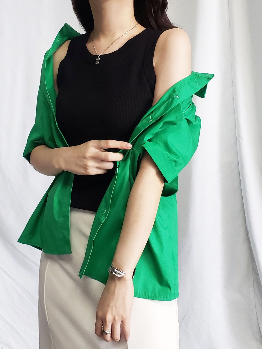 ブラック系のタンクトップ、グリーン系のシャツ/ブラウス、ホワイト系のスカートを着用したレディースの夏コーディネートの1枚目の写真