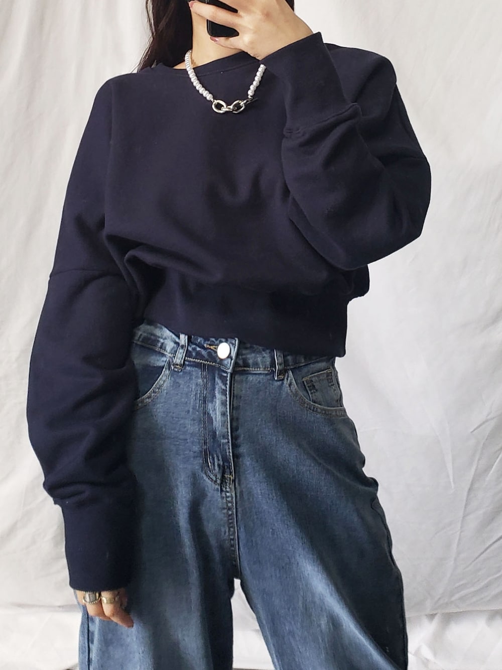 グレー系のスラックス、グレー系のスウェット、ブラック系のショルダーバッグを着用したレディースの冬コーディネートの2枚目の写真