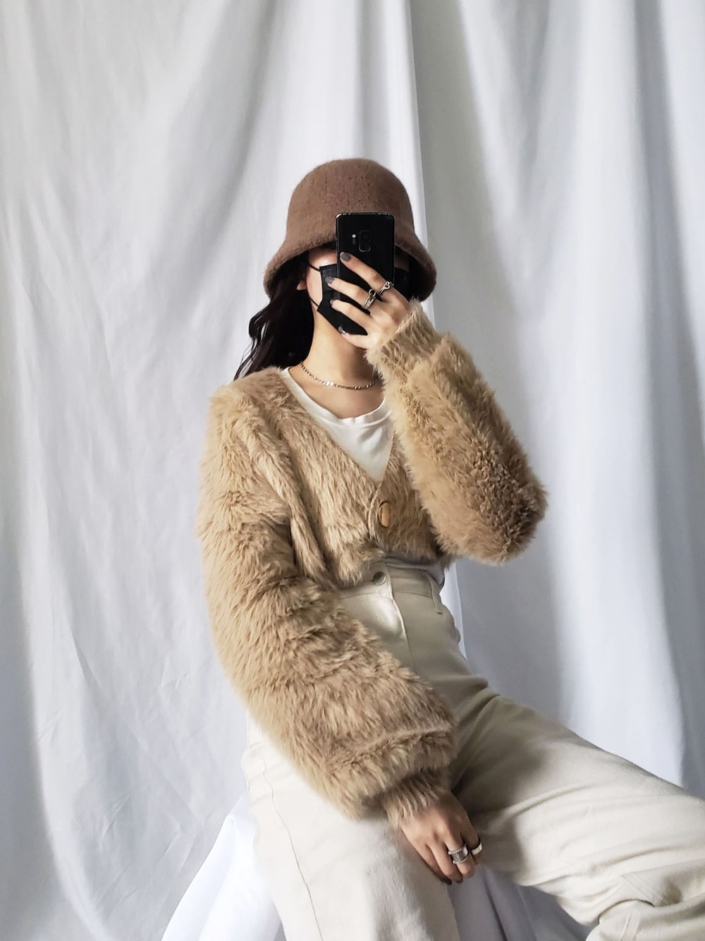 パープル系のニット/セーター、ブラック系のハットを着用したレディースの冬コーディネートの3枚目の写真