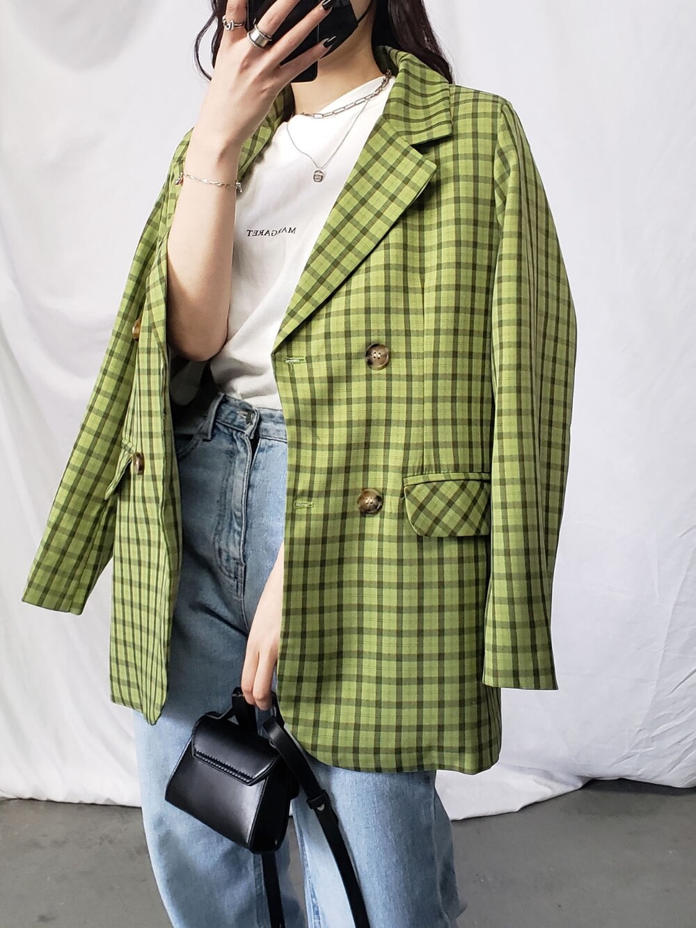 グリーン系のテーラードジャケット、ブルー系のデニムパンツを着用したレディースの春コーディネートの3枚目の写真