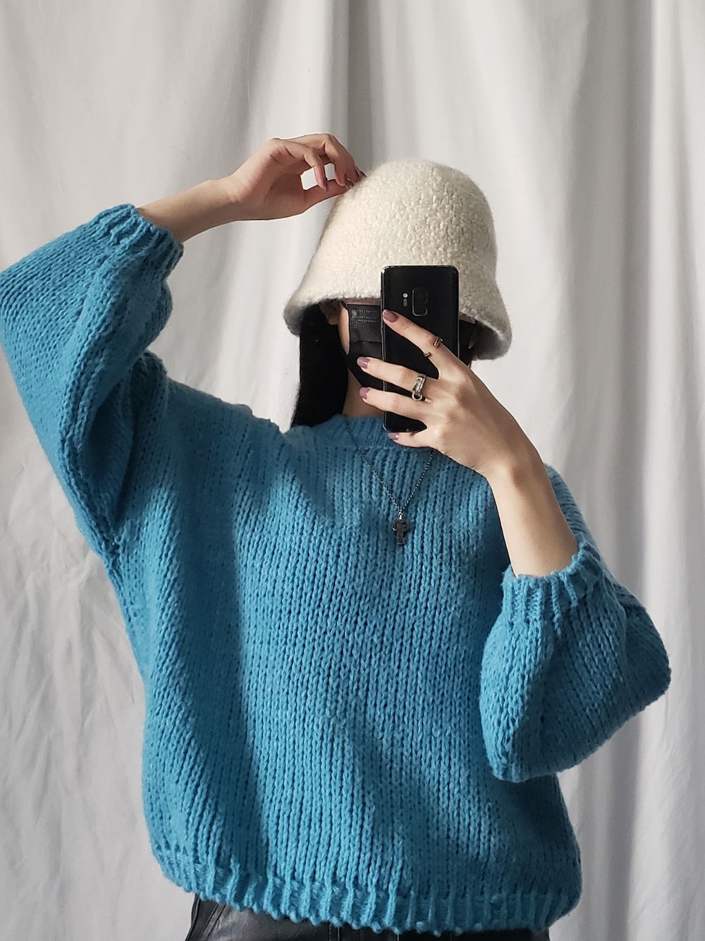 パープル系のニット/セーター、ブラック系のハットを着用したレディースの冬コーディネートの4枚目の写真