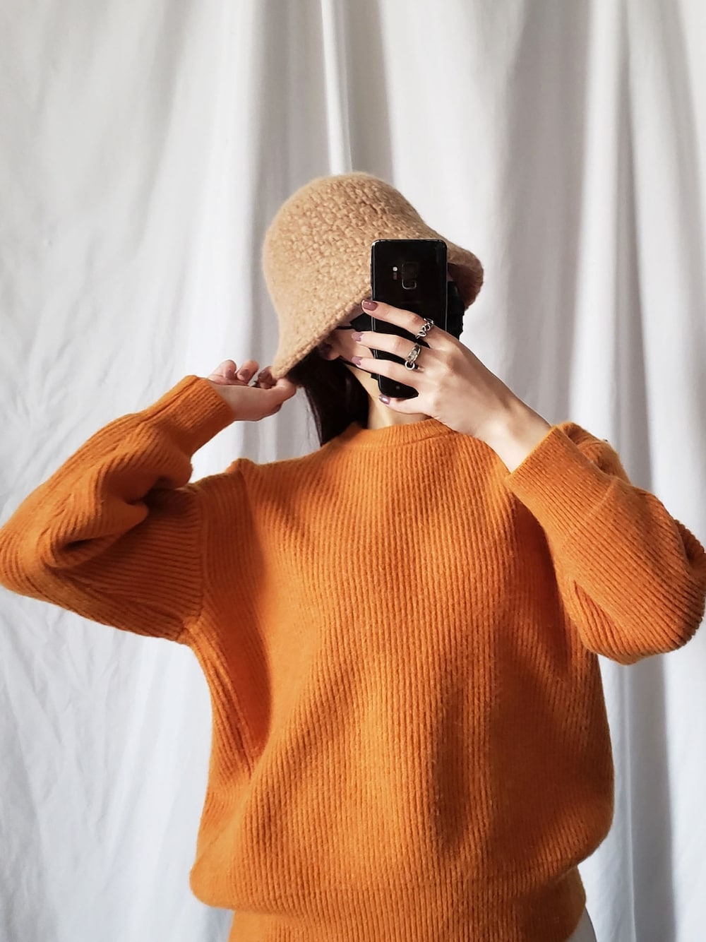 パープル系のニット/セーター、ブラック系のハットを着用したレディースの冬コーディネートの5枚目の写真