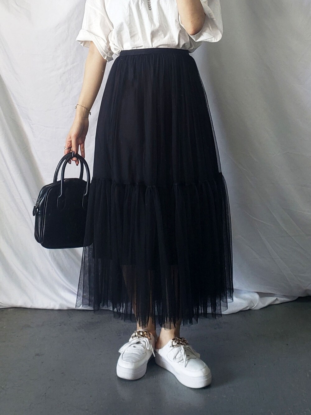 グレー系のスカート、ブルー系のスウェットを着用したレディースの春コーディネートの4枚目の写真