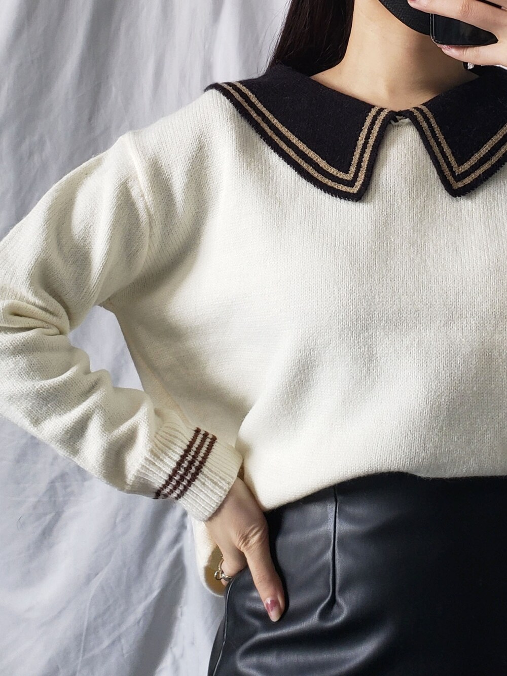 ホワイト系のスカート、ブラウン系のトートバッグ、ベージュ系のニット/セーターを着用したレディースの冬コーディネートの5枚目の写真