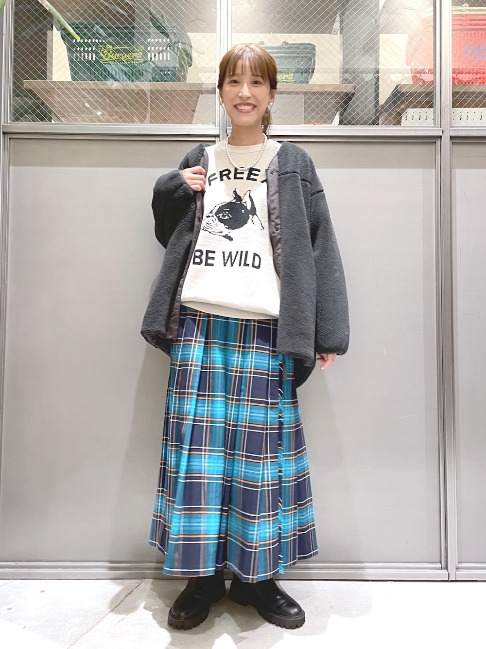 ベージュ系のニット/セーター、グレー系のブルゾン、ブルー系のスカートを着用したレディースの秋コーディネートの1枚目の写真