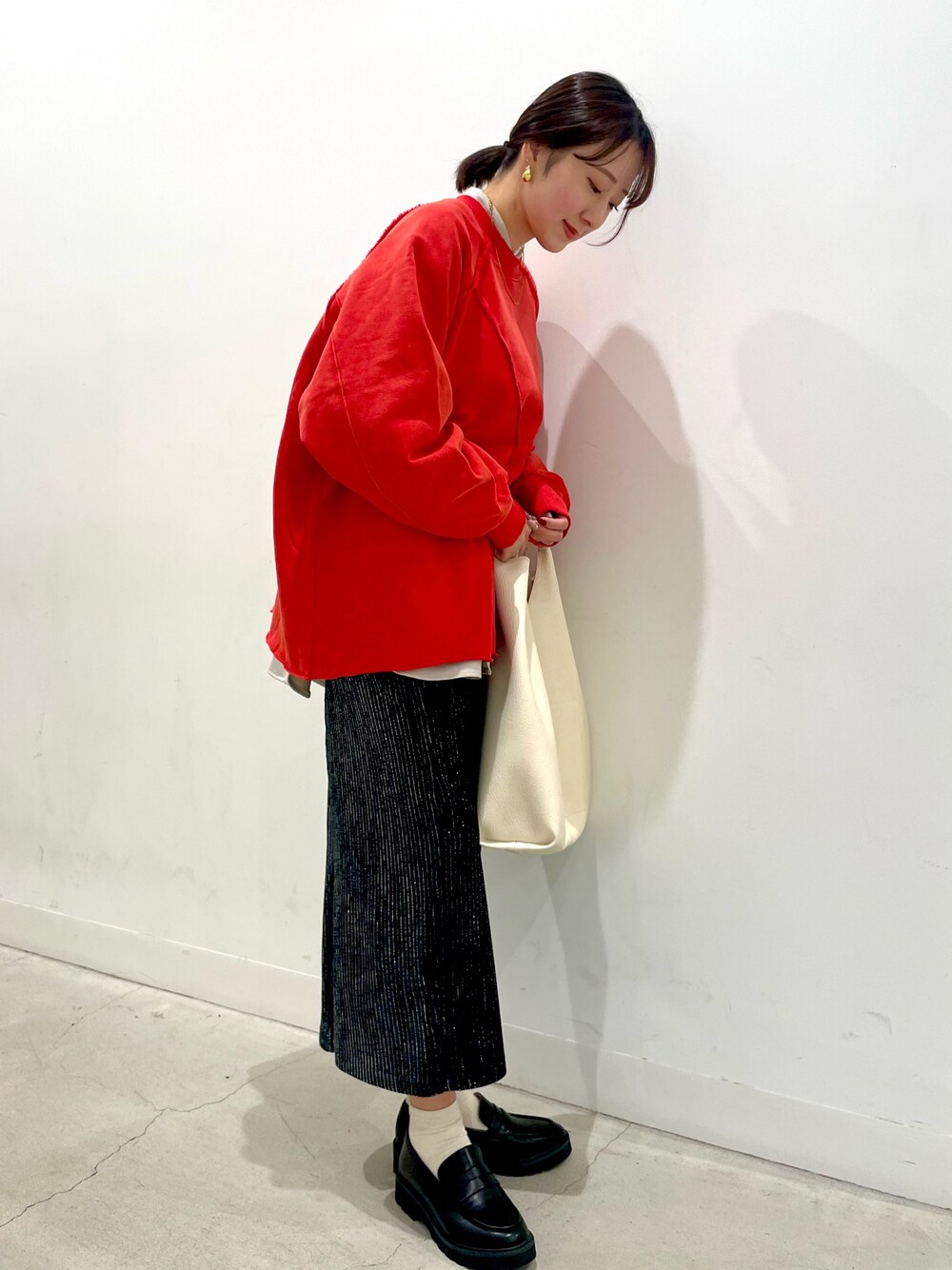 ベージュ系のシャツ/ブラウス、レッド系のTシャツ/カットソー、ブラック系のスカートを着用したレディースの秋コーディネートの1枚目の写真