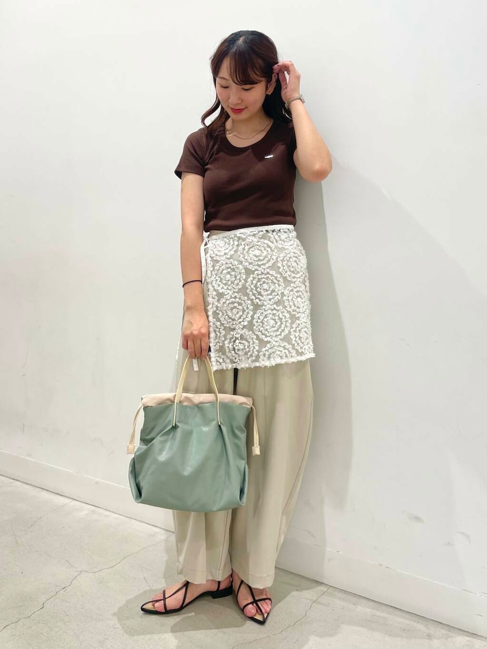 ブラック系のサンダル、ホワイト系のスカート、ベージュ系のその他パンツを着用したレディースの夏コーディネートの1枚目の写真