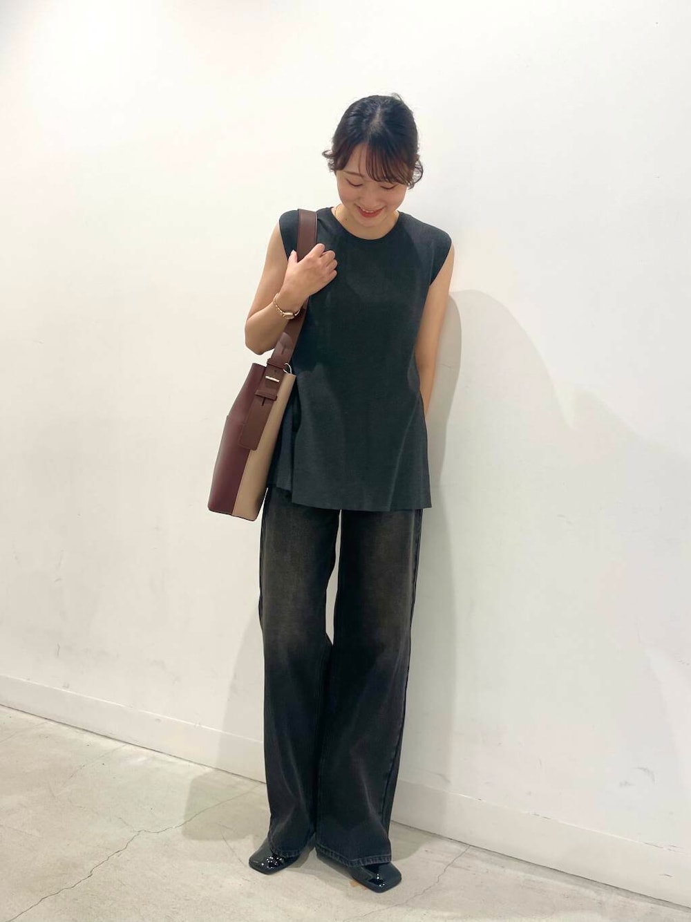 ブラウン系のショルダーバッグ、グレー系のニット/セーター、ブラック系のその他シューズを着用したレディースの夏コーディネートの1枚目の写真