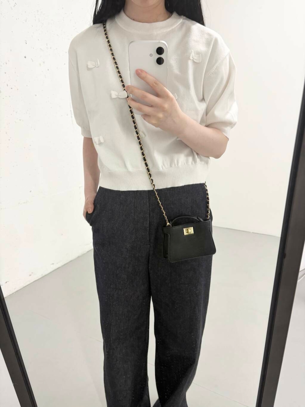 ブルー系のデニムパンツ、ホワイト系のニット/セーター、イエロー系のサンダルを着用したレディースの夏コーディネートの1枚目の写真
