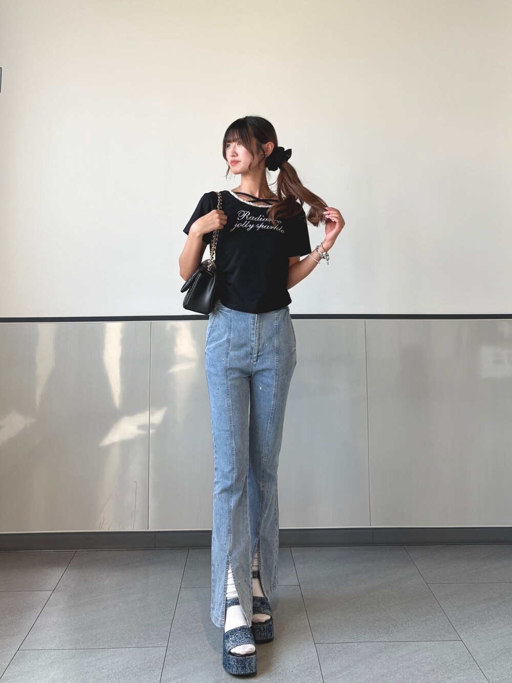 ブラック系のTシャツ/カットソー、ブルー系のデニムパンツ、ブラック系のショルダーバッグを着用したレディースの秋コーディネートの1枚目の写真