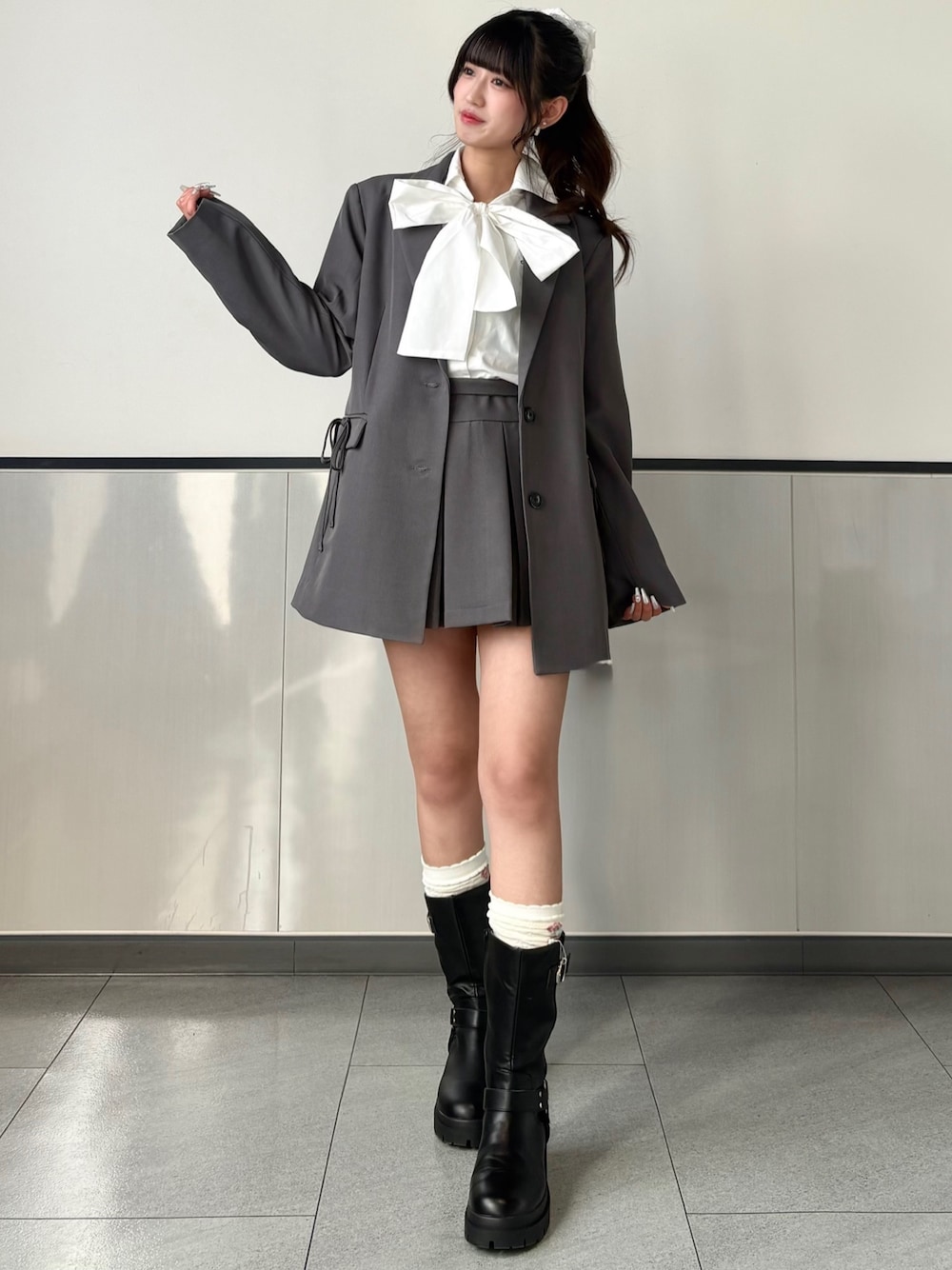 グレー系のテーラードジャケット、グレー系のスカート、ホワイト系のシャツ/ブラウスを着用したレディースの春コーディネートの1枚目の写真