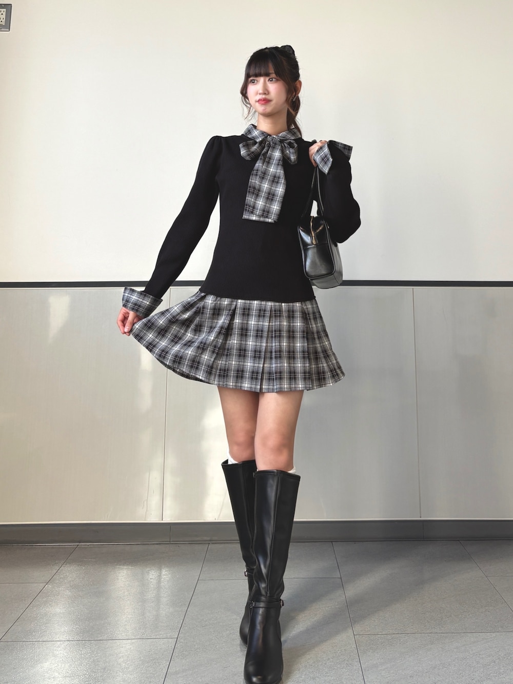 ブラック系のワンピース、ブラック系のハンドバッグ、ブラック系のブーツを着用したレディースの秋コーディネートの1枚目の写真