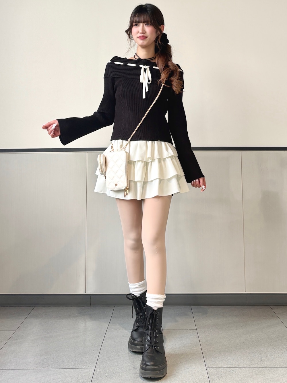 ブラック系のニット/セーター、ホワイト系のスカートを着用したレディースの冬コーディネートの1枚目の写真