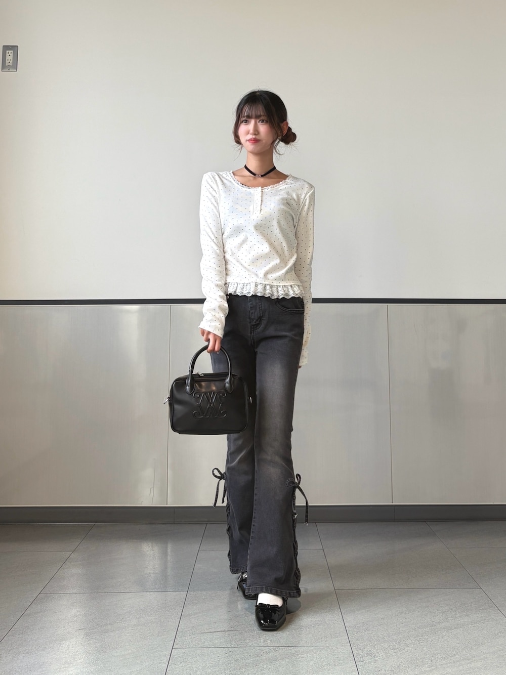 ブラック系のハンドバッグ、ホワイト系のTシャツ/カットソー、ブラック系のパンプスを着用したレディースの秋コーディネートの1枚目の写真