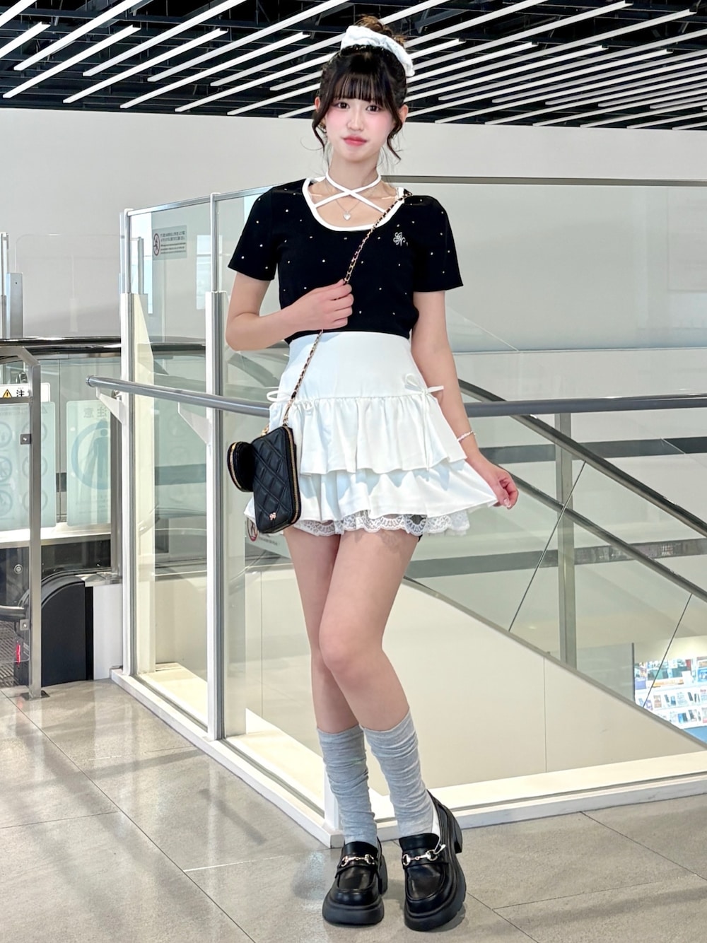 ブラック系のTシャツ/カットソー、ブラック系のパンプス、ホワイト系のスカートを着用したレディースの春コーディネートの1枚目の写真