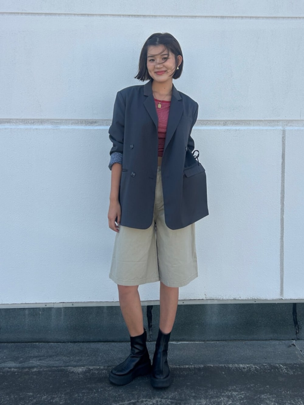 ベージュ系のデニムパンツ、グレー系のテーラードジャケット、レッド系のTシャツ/カットソーを着用したレディースの夏コーディネートの1枚目の写真