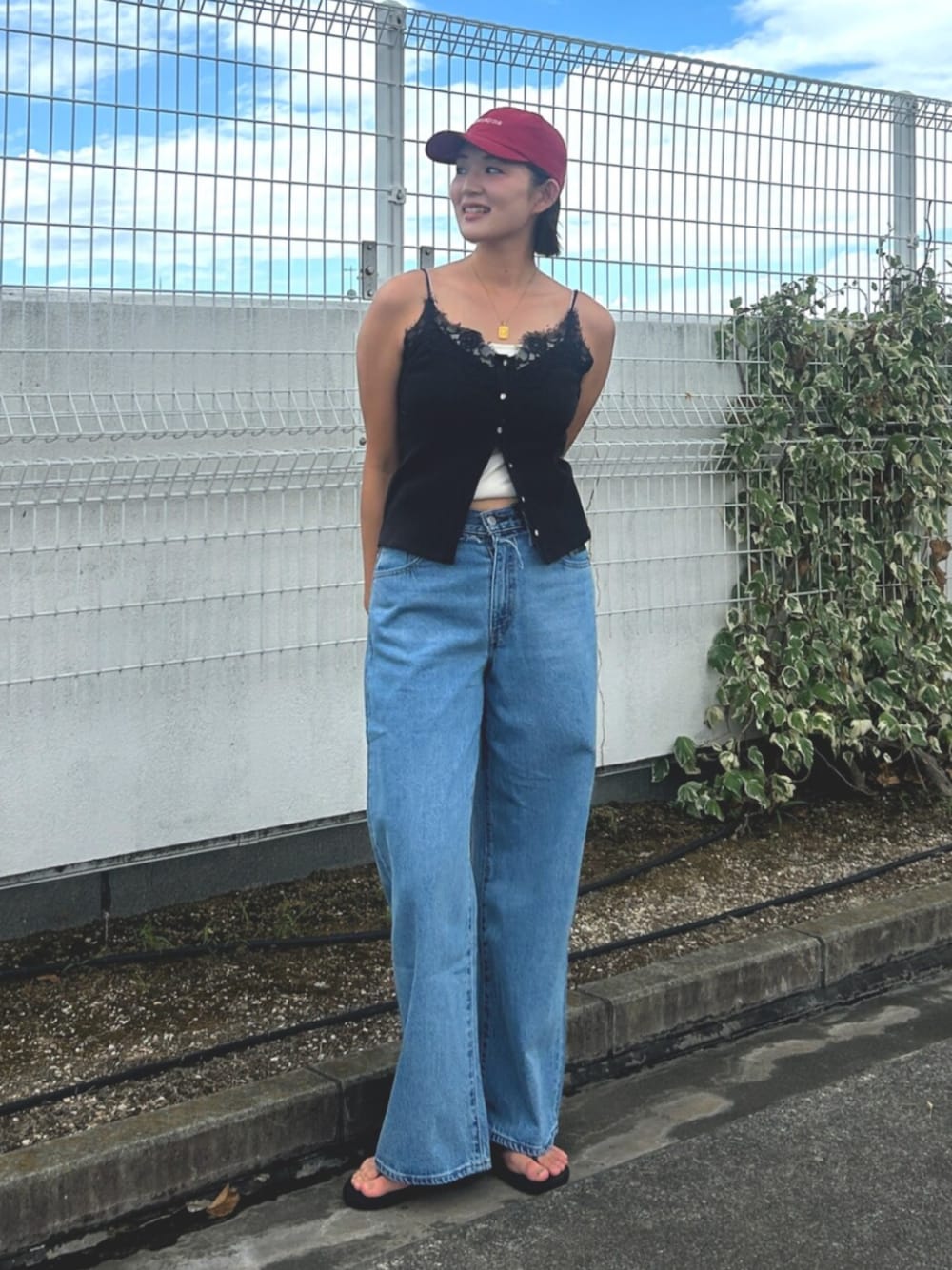 ブルー系のデニムパンツ、ブラック系のTシャツ/カットソー、レッド系のキャップを着用したレディースの夏コーディネートの1枚目の写真