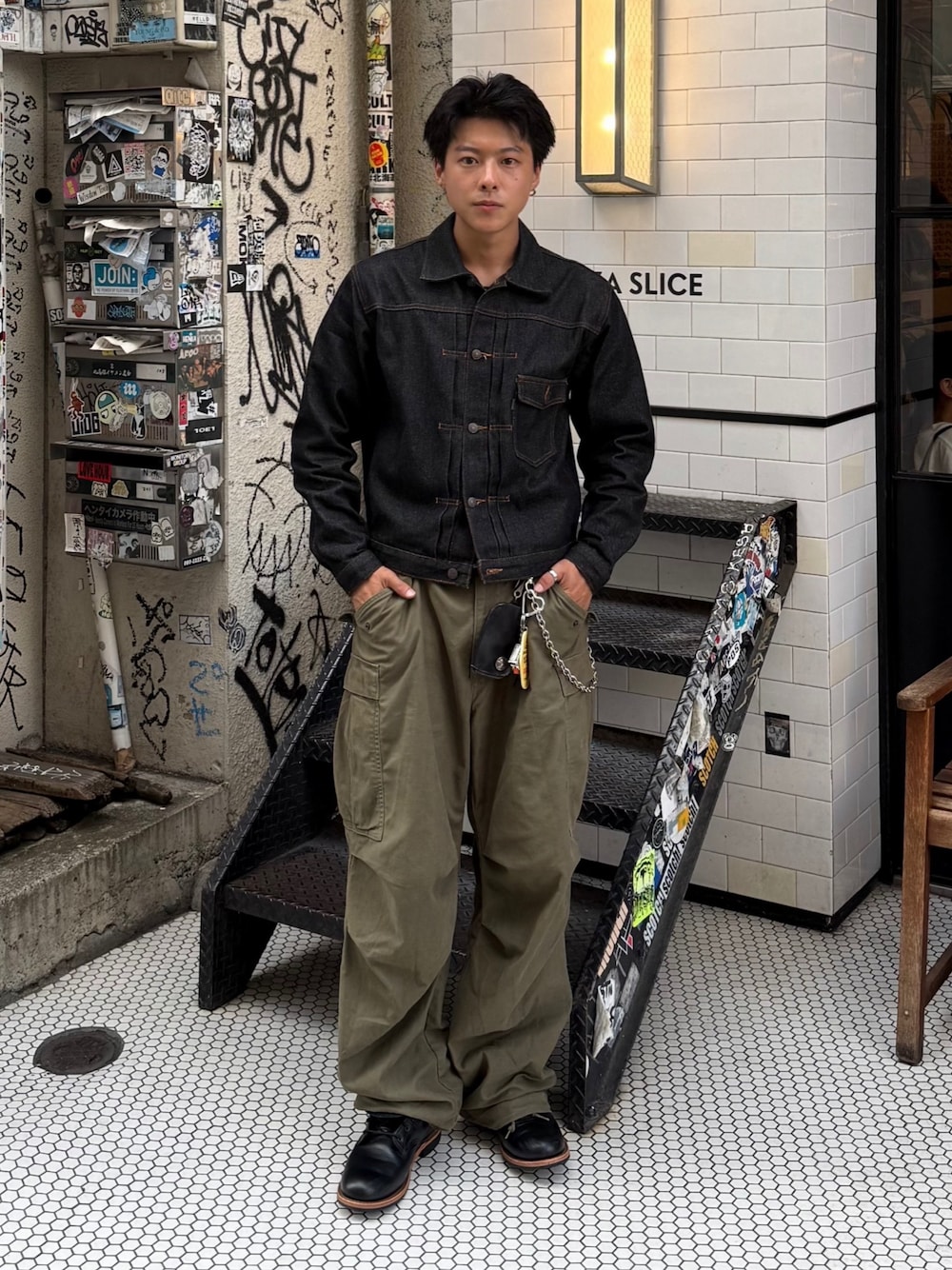 ブラック系のデニムジャケット、グリーン系のカーゴパンツ、グレー系のローファーを着用したメンズの秋コーディネートの1枚目の写真