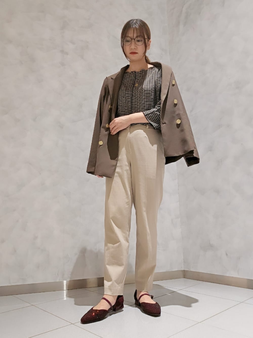 レッド系のパンプス、ベージュ系のパンツ、ブラウン系のテーラードジャケットを着用したレディースの秋コーディネートの1枚目の写真