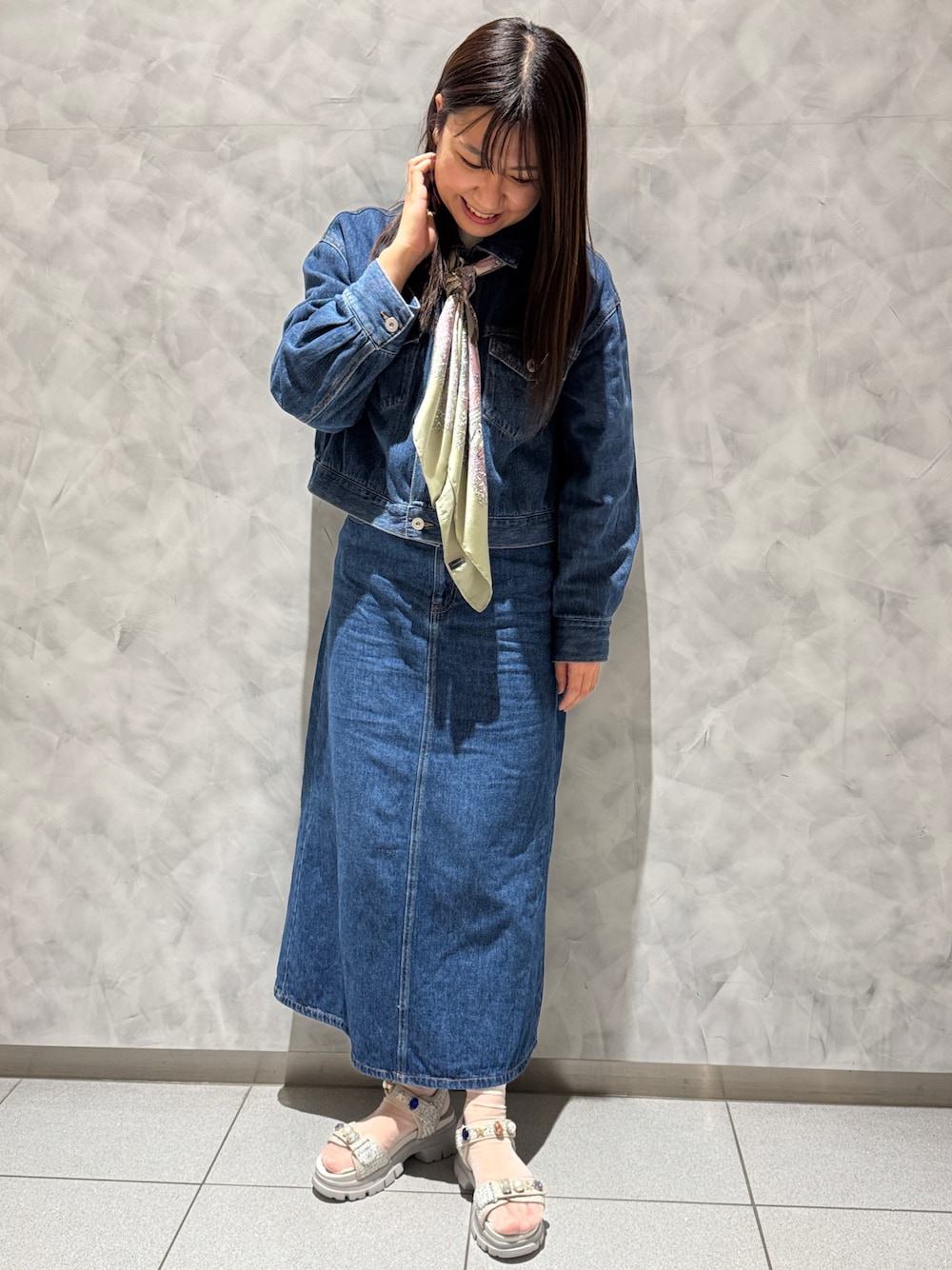 グレー系のサンダル、ブルー系のデニムジャケット、ブルー系のデニムスカートを着用したレディースの春コーディネートの1枚目の写真
