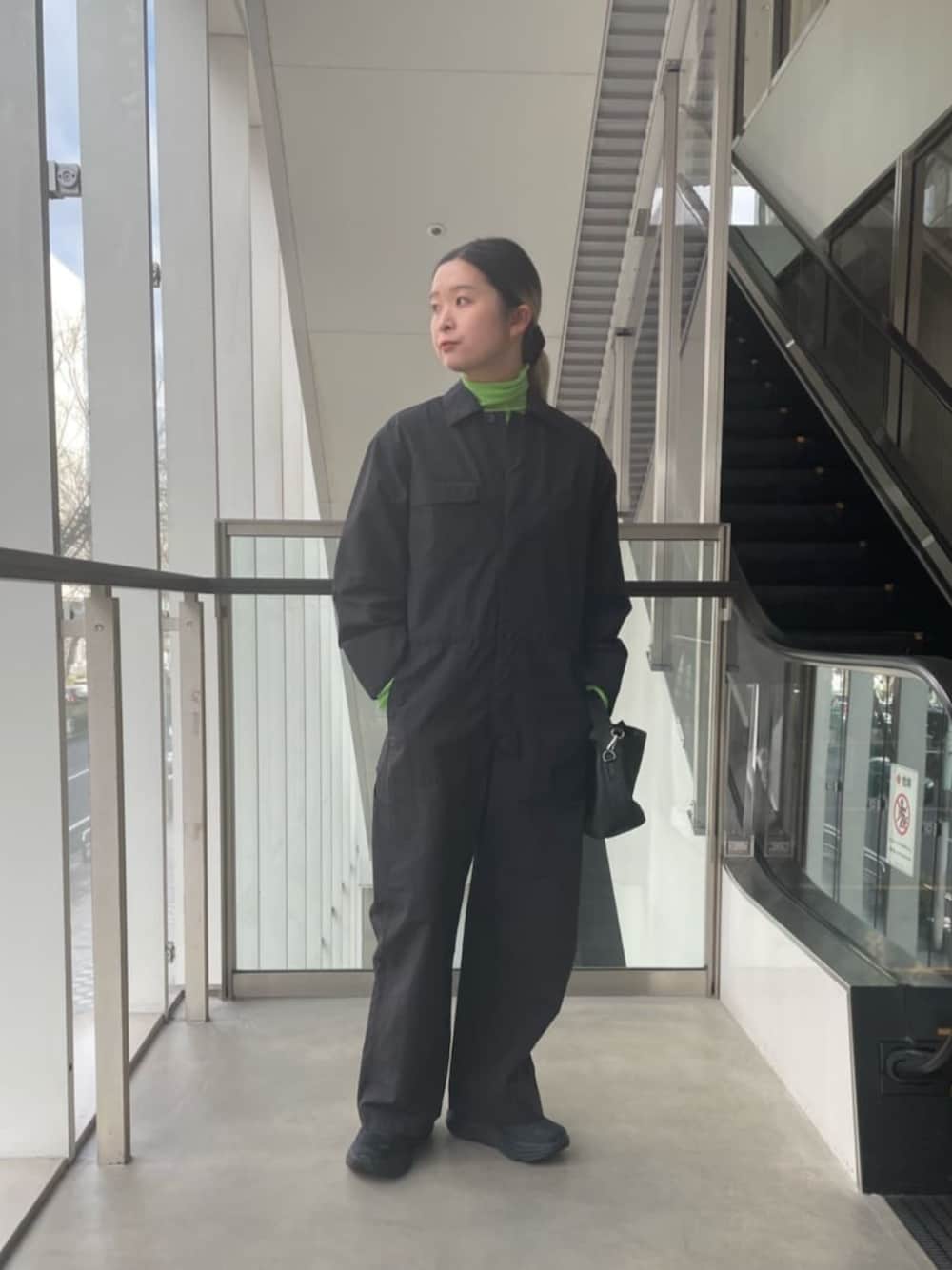 ブラック系のつなぎ/オールインワン、グリーン系のTシャツ/カットソー、ブラック系のショルダーバッグを着用したレディースの冬コーディネートの1枚目の写真