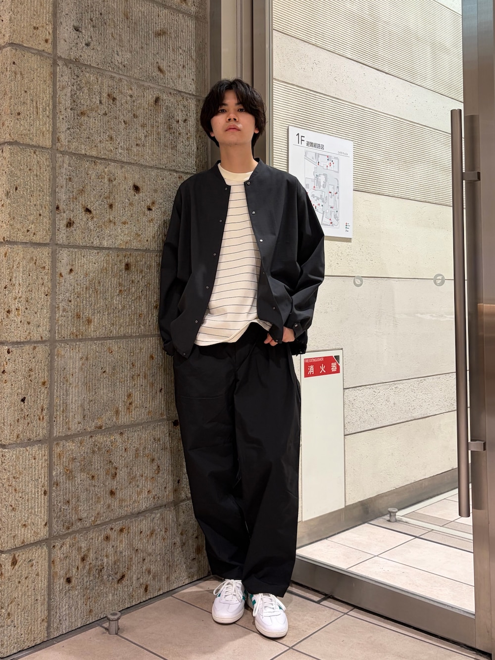 グレー系のブルゾン、ホワイト系のTシャツ/カットソー、ブラック系のその他パンツを着用したメンズの春コーディネートの1枚目の写真